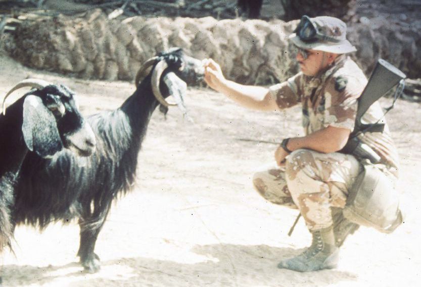 Desert Storm soldier feeding goats--no staring here!